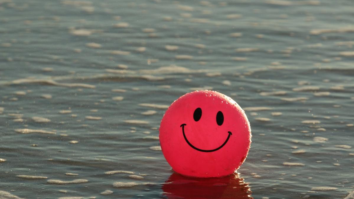 A red beach ball with a smiley face