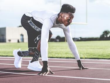 An athlete in the starting position on a track