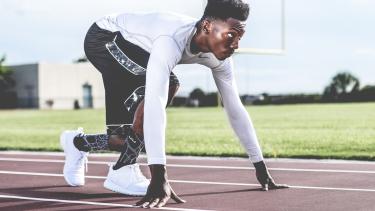 An athlete in the starting position on a track