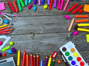 Brightly coloured school supplies arranged in a circle