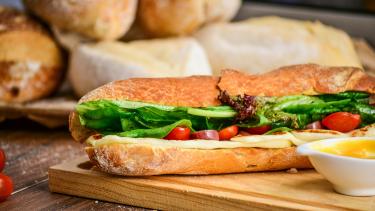 A meat and veggie sub on a cutting board