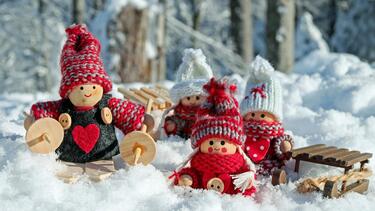 Doll figures dressed up in christmas outfits